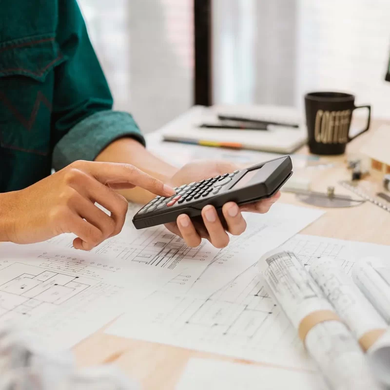 Close up Architect or Engineer pressing on calculator for calculating value estimating for safety with the drawing construction building. Close up Architect or Engineer pressing on calculator for calculating value estimating for safety with the drawing construction building.