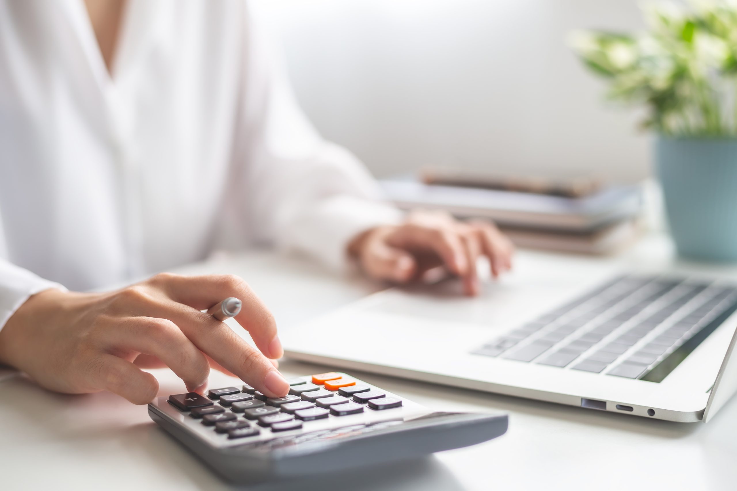 Woman entrepreneur using calculator, Saving money and calculatin Woman entrepreneur using calculator.