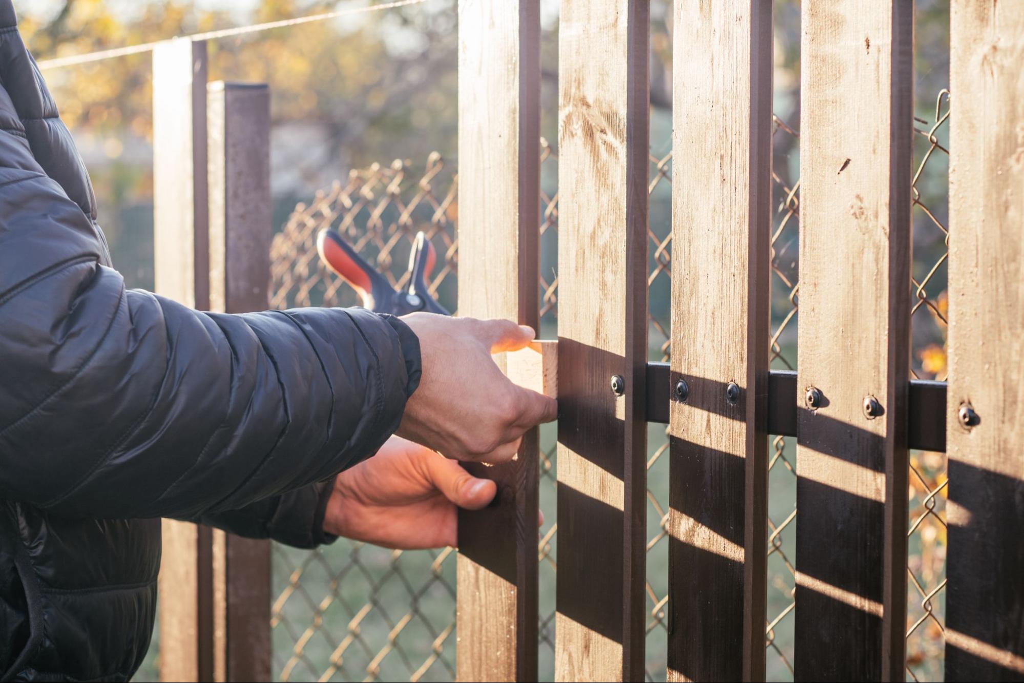 A man is installing fences.