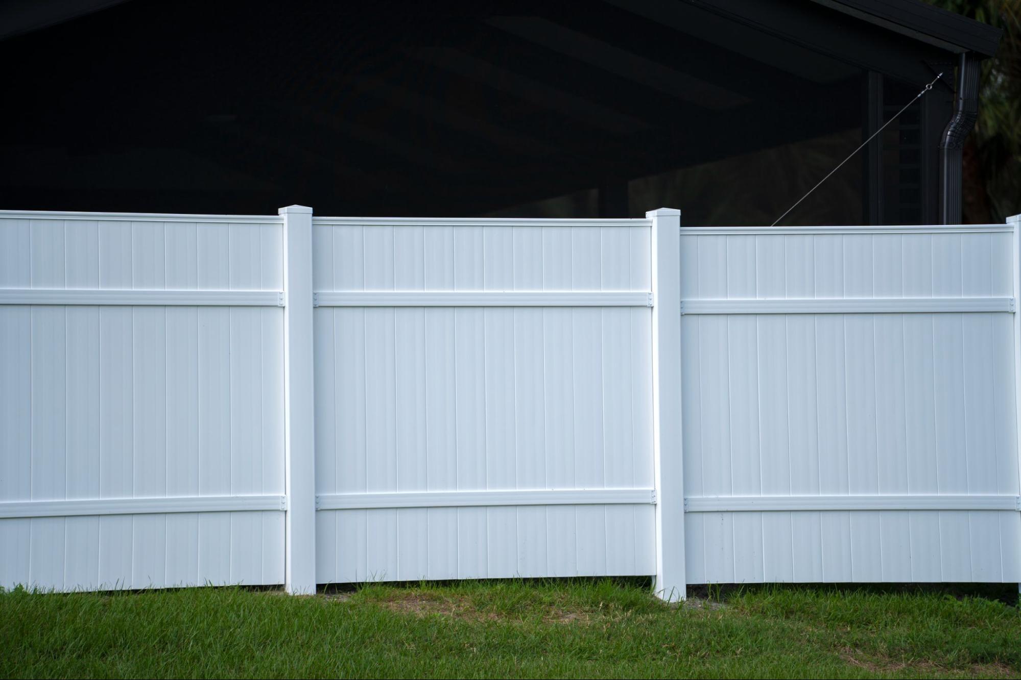 Vinyl fence on a grassy yard.