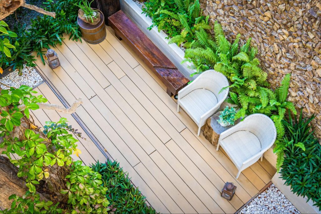 Top view of a decorated outdoor patio with empty chairs on a wood-grain vinyl deck