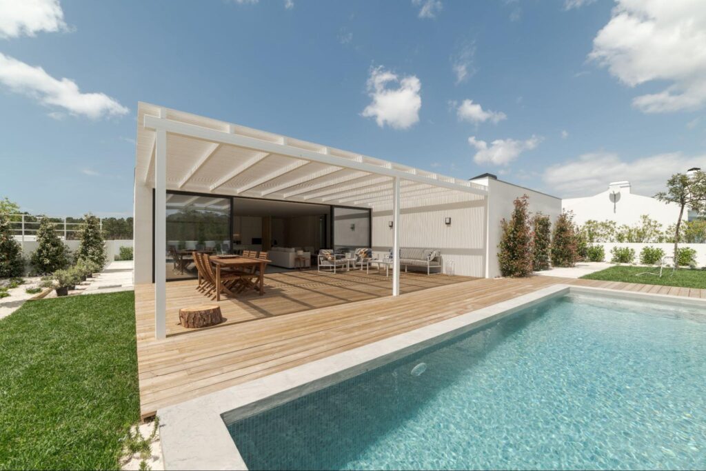 Modern home with garden, pool, and a sleek wooden deck beneath a stylish patio cover
