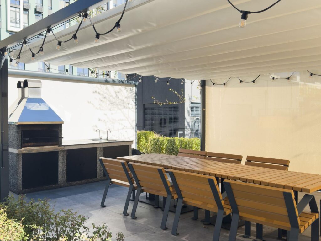 Spacious barbecue area with a patio cover providing shade and style.