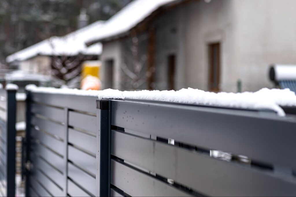 A steel fence covered in snow.